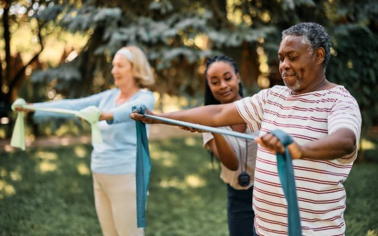 black-senior-man-practicing-with-power-band-on-exercise-class-at-residential-care-home.jpg
