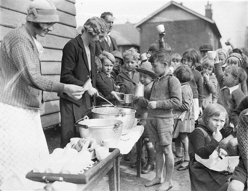 Schoolchildren line up for a free soup and a slice of bread in the Great Depress.jpg